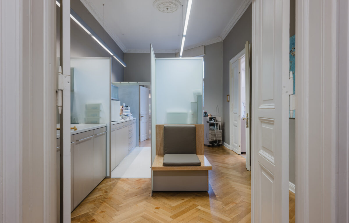 Blick in die Praxisräume von achtzahn mit Sitzplatz, Glasabtrennungen und Parkettboden